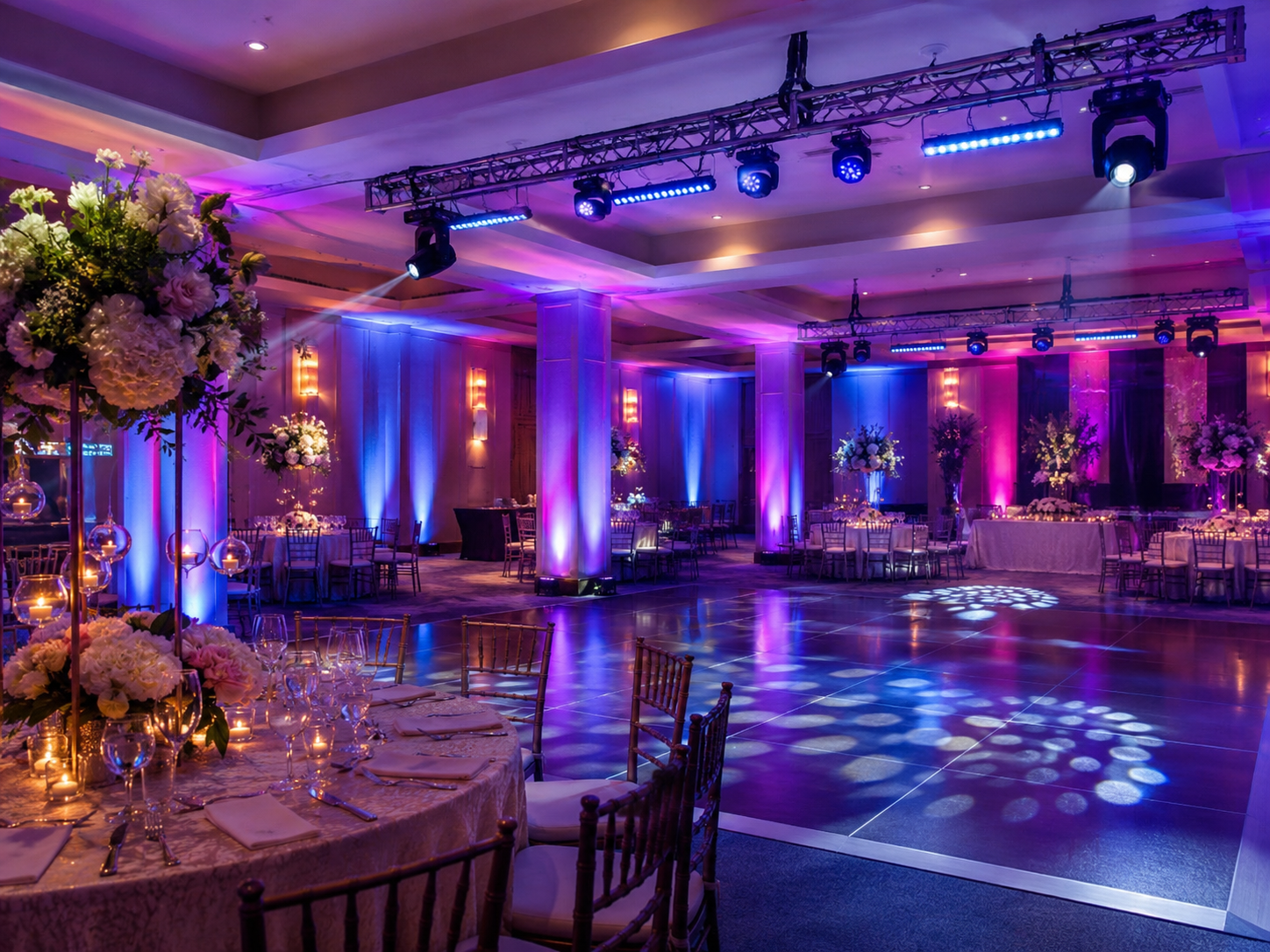 Salón de eventos ambientado con uplighting, luces LED y pista iluminada