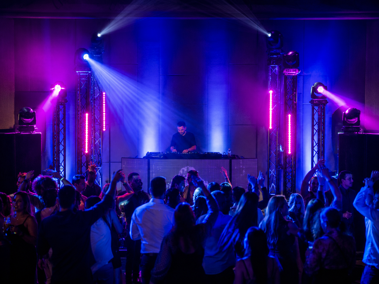 DJ semiprofesional en un evento mediano con iluminación coordinada, PAR LED, moving heads y barras LED