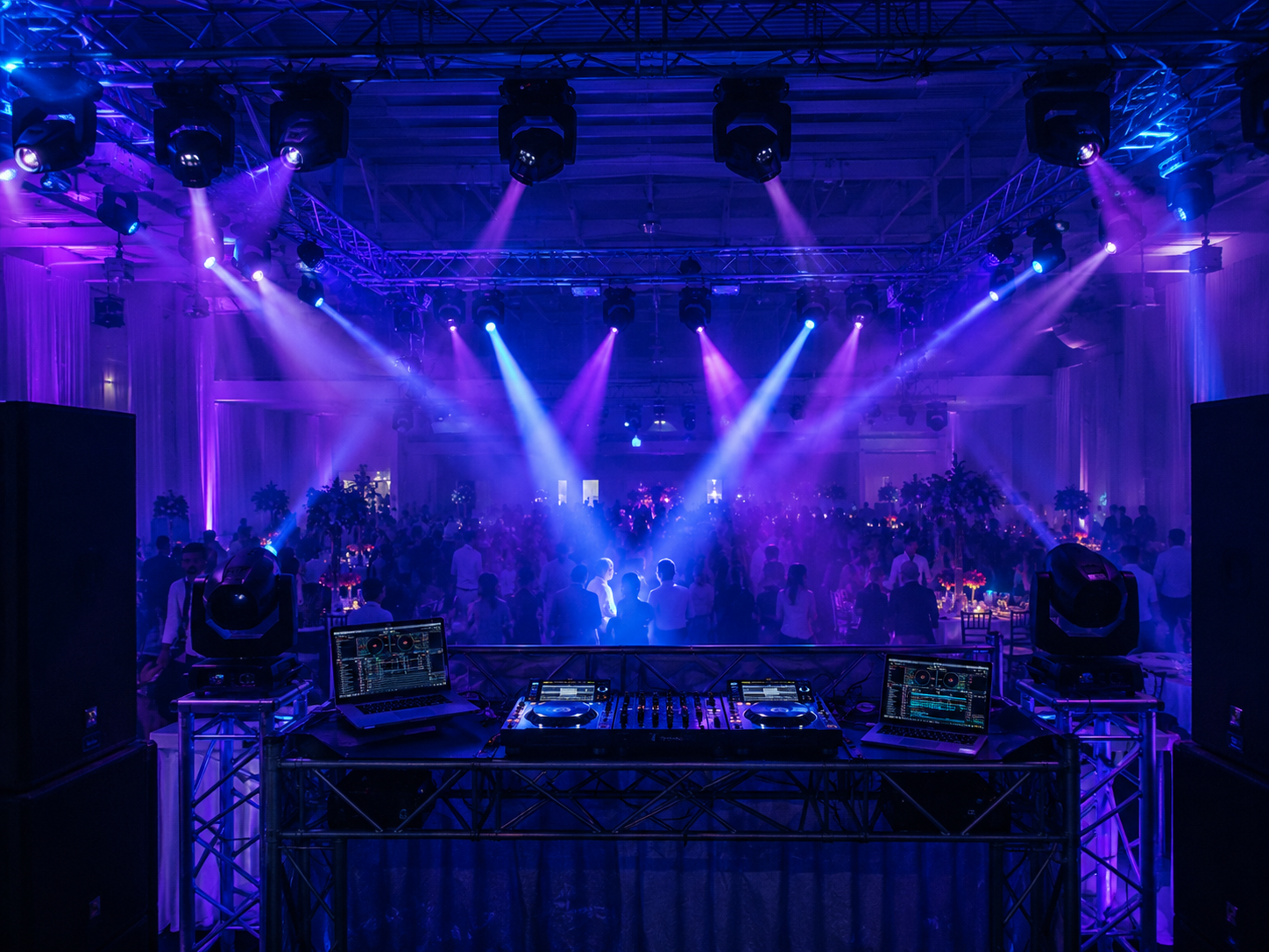 Montaje de DJ semiprofesional en un evento mediano con haces visibles, baños de color y haze ligero